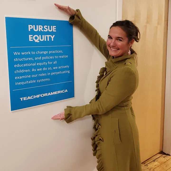 Inez Ribustello - Teach for America - Stands in Front of Pursue Equity Sign